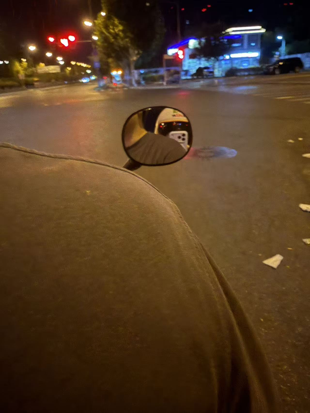夜晚电动车后座望向后视镜的街景